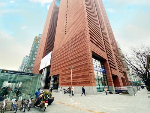 Un grand bâtiment avec des gens qui marchent devant lui dans l'établissement Ocloud Hotel Gangnam, à Séoul