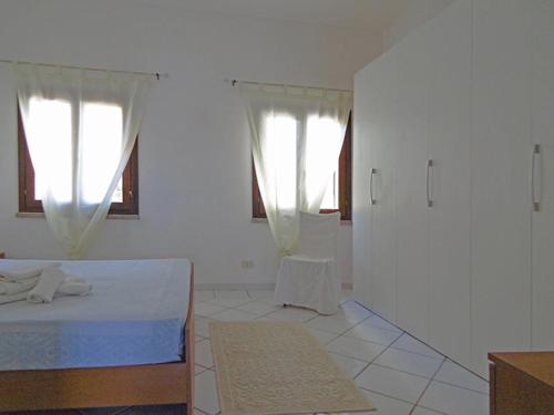 坎尼吉翁的住宿－bilo 28 asfodeli，白色的客房设有一张床和两个窗户。