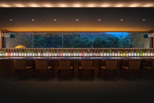 a bar with a row of chairs in a room at Iizaka Onsen Surikamitei Ohtori in Fukushima