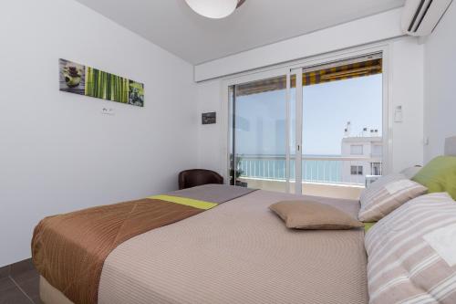 a bedroom with two beds and a large window at GORGEOUS APT with TERRACE, ELEVATOR, AC, FREE PARKING - Le Régis in Cagnes-sur-Mer