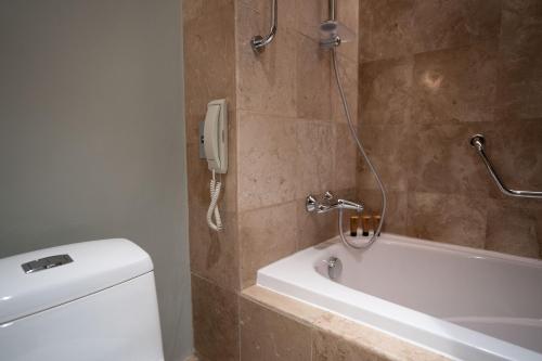 a bathroom with a phone on the wall next to a toilet at Marco Polo Plaza Cebu in Cebu City