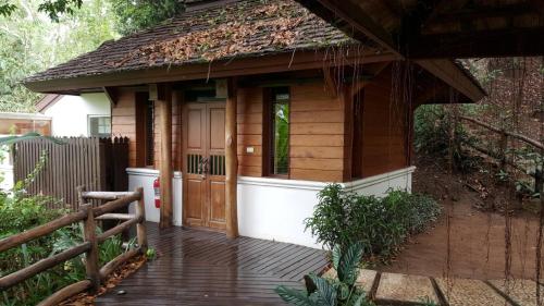 a small wooden dog house with a wooden deck at Vanilla hill (hill lodge) in Ban Muang Ha