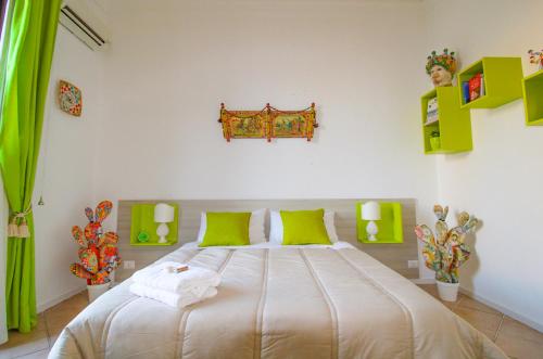 1 dormitorio con 1 cama grande con detalles verdes en THE PALACE B&B and Apartments, en Santo Stefano di Camastra