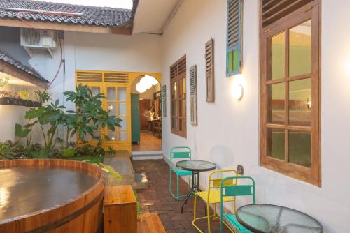 a patio with tables and chairs in a building at Wonderloft Hostel Jogja in Yogyakarta