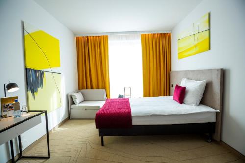 a hotel room with a bed and a chair at Arche Hotel Krakowska in Warsaw