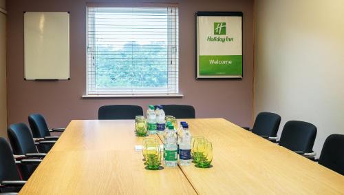 a conference room with a table with glasses on it at Holiday Inn London Brent Cross, an IHG Hotel in London