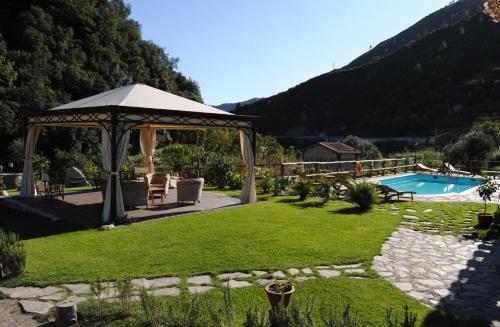 een tuin met een prieel en een zwembad bij Le Macine Del Confluente in Badalucco