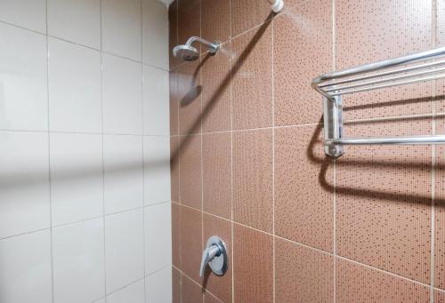 a shower in a bathroom with a shower head at Warm and Homey 1BR Apartment at Atlanta Residences By Travelio in Pondokcina