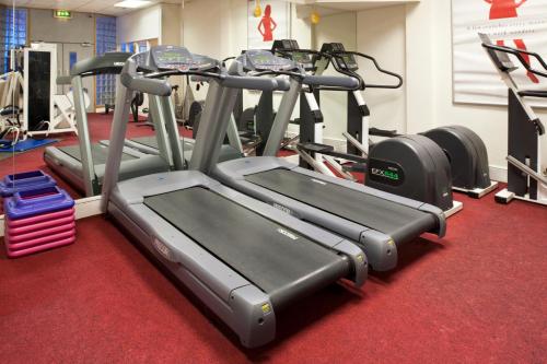 a gym with several tread machines on a red carpet at Holiday Inn Bolton Centre by IHG in Bolton
