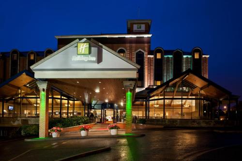 un edificio con una torre de reloj delante de él en Holiday Inn Bolton Centre, an IHG Hotel, en Bolton