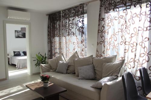 a living room with a white couch in front of a window at LEO Apartment FREE PARKING - Augusta in Bratislava