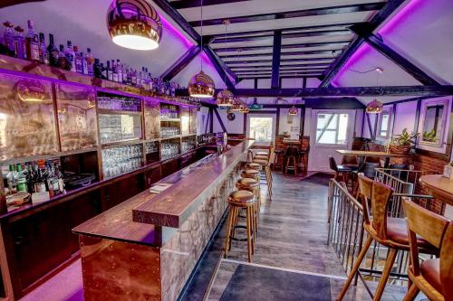 a bar with purple lighting in a pub at Venngasthof Zur Buche in Monschau