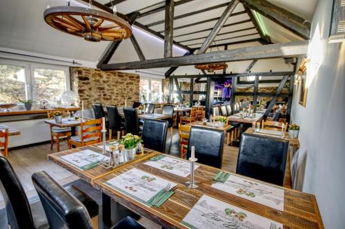 a dining room with a long table and chairs at Venngasthof Zur Buche in Monschau