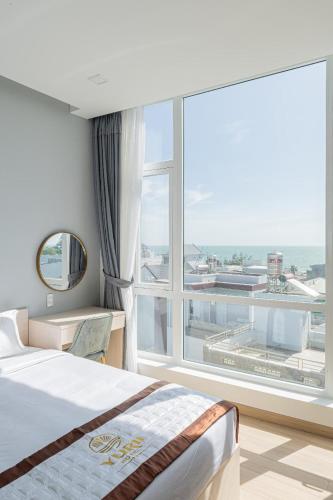 a bedroom with a bed and a large window at Yurii Hotel in Phan Thiet