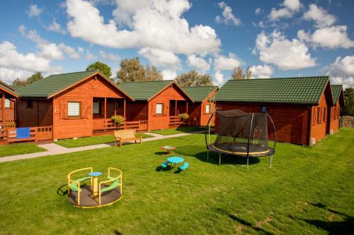 a yard with two playground equipment in front of a cabin at WICIE Domki na Polanie in Wicie