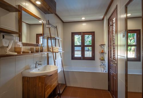 a bathroom with a sink and a bath tub at Sanctuary Hotel Luang Prabang in Luang Prabang