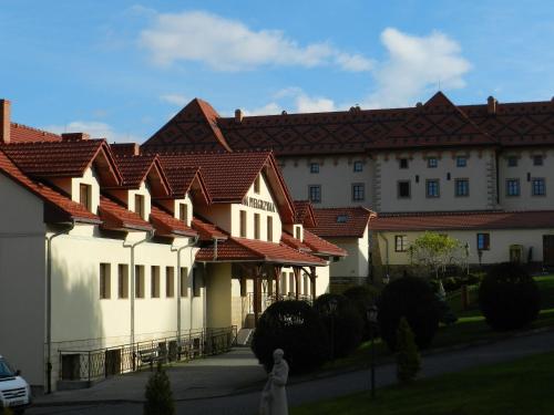 un grand bâtiment blanc avec des toits rouges dans l'établissement Dom Pielgrzyma, à Kalwaria Zebrzydowska