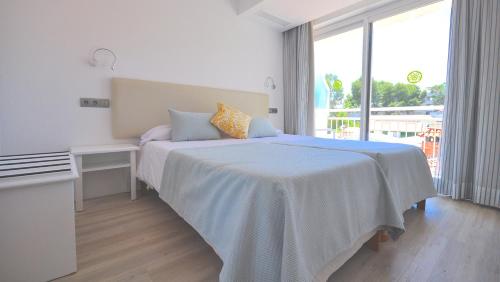 a bedroom with a white bed and white walls at Houm Nets - Adults Only in Playa de Palma