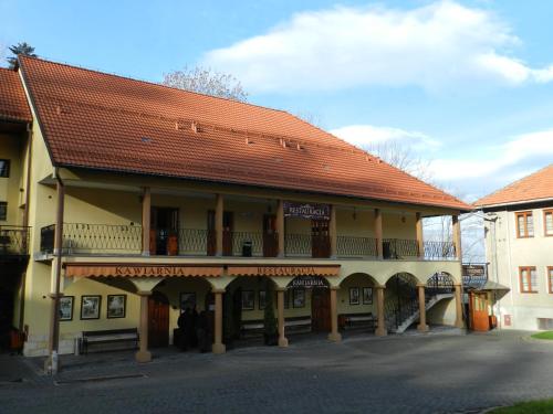 a large building with a red roof and a street at Dom Pielgrzyma in Kalwaria Zebrzydowska