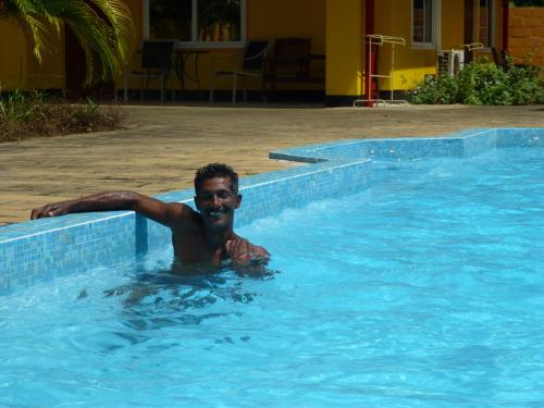 a man swimming in a swimming pool at Kekemba Apartments Paramaribo in Paramaribo