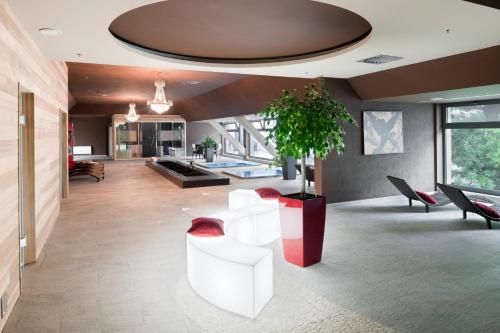 a living room with white furniture and a potted plant at Holiday Inn Trnava by IHG in Trnava