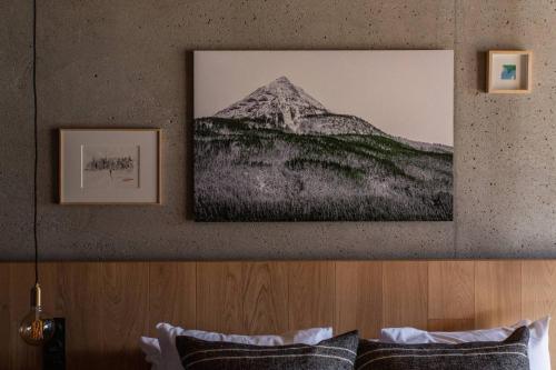 a picture of a mountain hanging above a bed at Hôtel Restaurant Le Monêtier in Le Monêtier-les-Bains