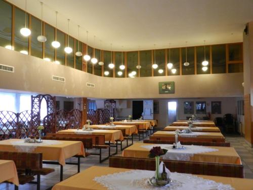 un comedor con mesas, sillas y luces en Dom Pielgrzyma, en Kalwaria Zebrzydowska