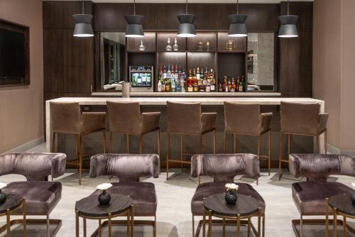 a bar in a restaurant with chairs and a counter at Holiday Inn Boston Logan Airport - Chelsea by IHG in Chelsea