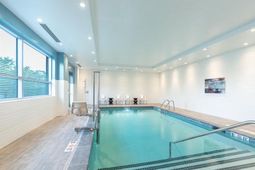 a swimming pool in a building with a large window at Holiday Inn Boston Logan Airport - Chelsea by IHG in Chelsea