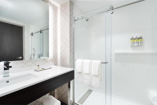 un bagno bianco con lavandino e doccia di Holiday Inn Boston Logan Airport - Chelsea by IHG a Chelsea