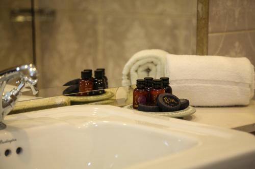 a bathroom sink with a mirror and a towel at Avalon House Hotel in Castlecomer