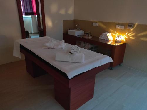 Cette chambre comprend un lit et une coiffeuse avec des lumières. dans l'établissement Holy River Hotel, à Rishikesh