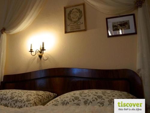 a bedroom with a bed and a light on the wall at Das Pernerhaus in Pöllau