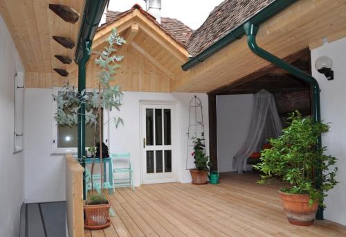 a patio with potted plants on a wooden deck at Das Pernerhaus in Pöllau