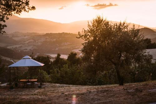 a picnic table with an umbrella on top of a hill at Agriturismo Amargi in Smerillo