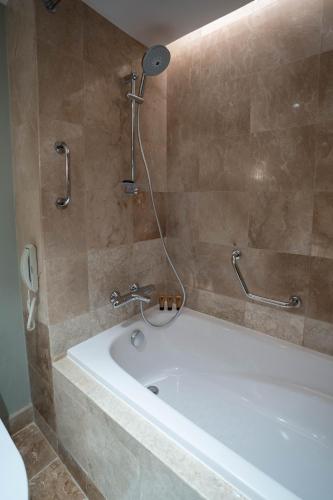 a bathroom with a bath tub with a shower at Marco Polo Plaza Cebu in Cebu City