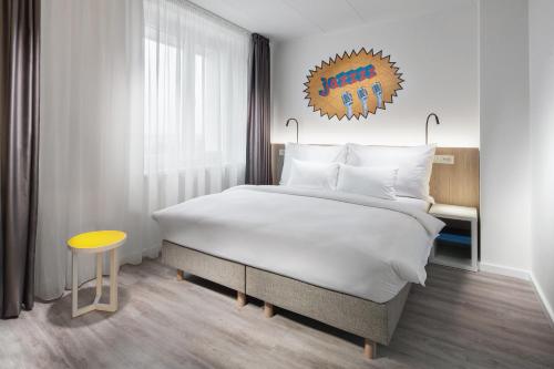 um quarto com uma cama grande e uma mesa amarela em Comfort Hotel Prague City em Praga