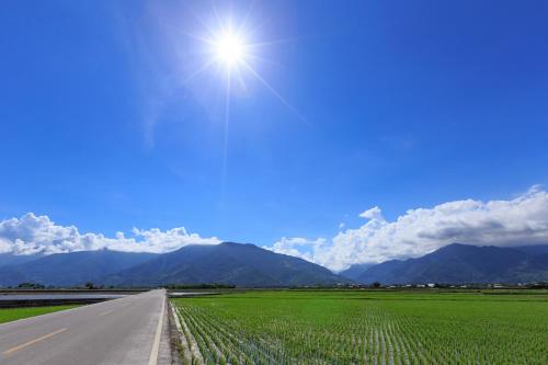an empty road with the sun in the sky at Cozy Blue B&B in Taitung City