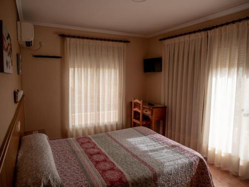 a bedroom with a bed and a large window at Hostal Durá in Torrellano