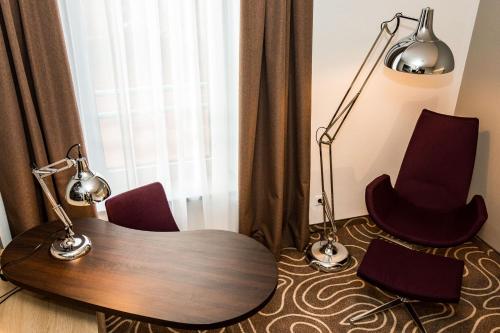 a room with a table and two chairs and a lamp at Holiday Inn Budapest-Budaörs by IHG in Budaörs