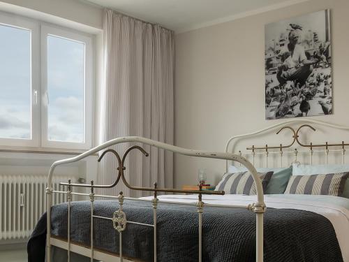 ein weißes Schlafzimmer mit einem Bett und einem Fenster in der Unterkunft Seesterne Residenz in Konstanz