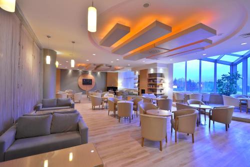 a restaurant with couches and tables and chairs at Euro Park Hotel Bursa in Bursa