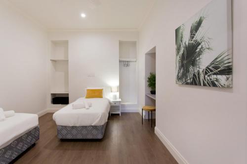 una stanza con due letti e un dipinto sul muro di Quokka at White Gum Lodge a Fremantle