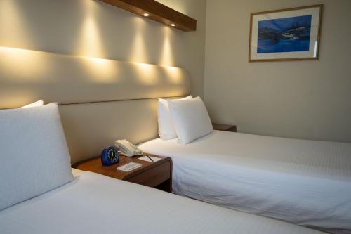 a hotel room with two beds and a telephone at Marco Polo Plaza Cebu in Cebu City