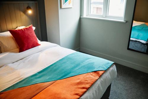 a bedroom with a bed with a red pillow and a window at Firefly in Bray