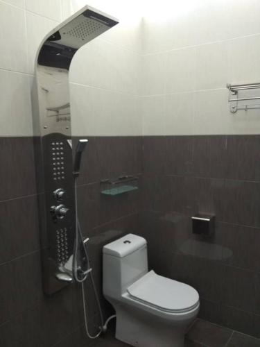 a bathroom with a white toilet and a shower at Captain's Cabin Resort - Naval Heritage (Swimming Pool) in Kota Bharu