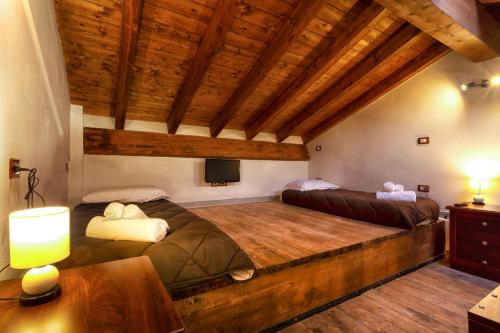a bedroom with two beds in a room with wooden ceilings at Villa Viktoria & Andras in Tredozio