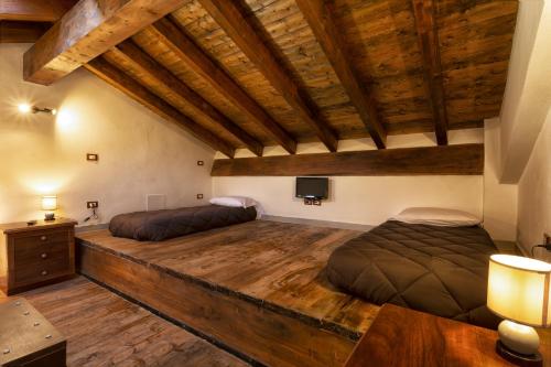 a bedroom with two beds and a tv on the wall at Villa Viktoria & Andras in Tredozio