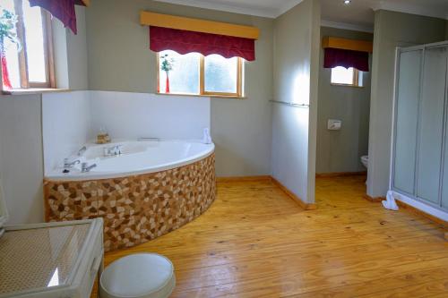 a bathroom with a large tub in the middle of the room at Sangiro Game Lodge in Bloemfontein