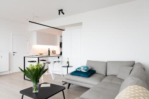- un salon avec un canapé et une table dans l'établissement Unieke Penthouse bij Brugge, à Blankenberge